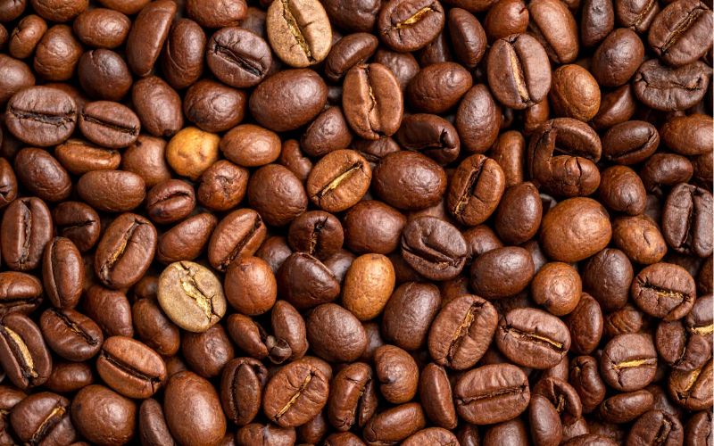 A close-up shot of a variety of roasted coffee beans, showcasing different colors and textures.