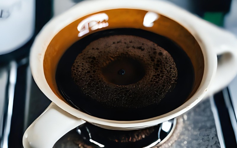 A close-up shot of a pour-over coffee bed, showing the characteristic bubbling 'bloom' as hot water is added.