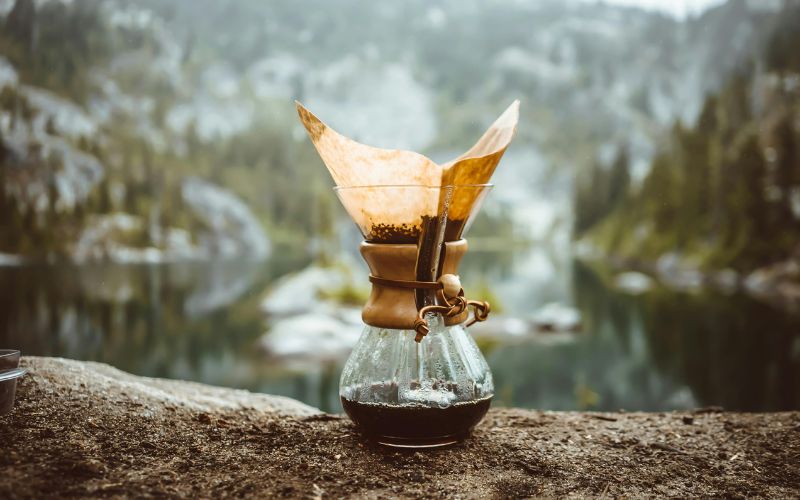 A classic Chemex brewer with its wooden collar, filled with freshly brewed coffee.