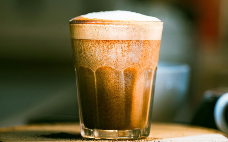 A glass of nitro cold brew, showcasing its characteristic cascading foam head.