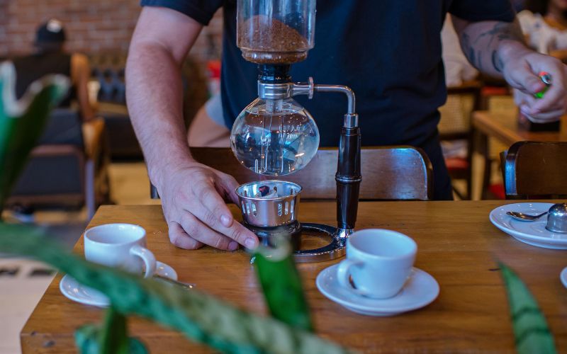 A dramatic shot of a siphon coffee maker, with water rising to the top chamber under pressure.